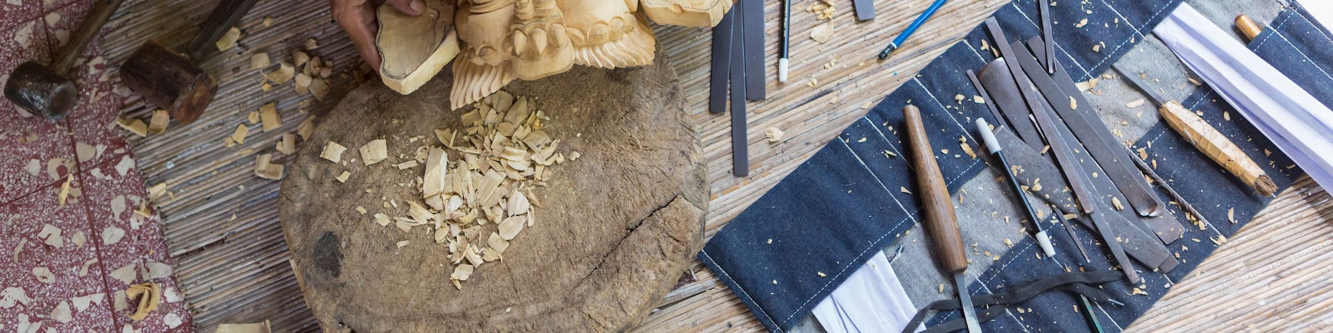 Craftsperson shaping wooden piece in studio