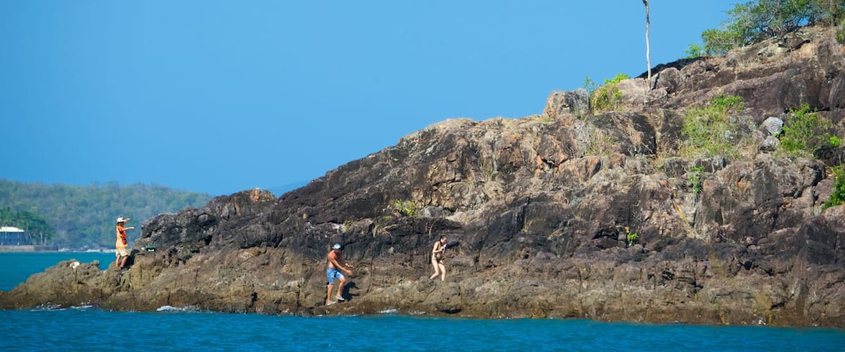 Conway National Park featuring rocky coastline as well as a small group of people