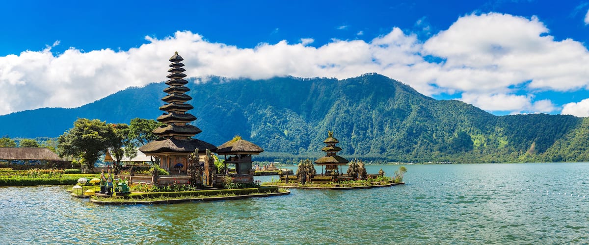 A serene lake with traditional Balinese temples and lush greenery.