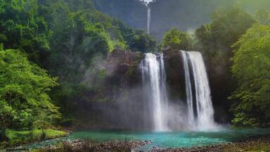 Twin Waterfall Rain Forest In Valley Like A Paradise Garden With Turquoise Green Pond and Blur Waterfall Mountain Behind. Curug Sodong Amidst Tropical Rain Forest in Global Geopark Ciletuh