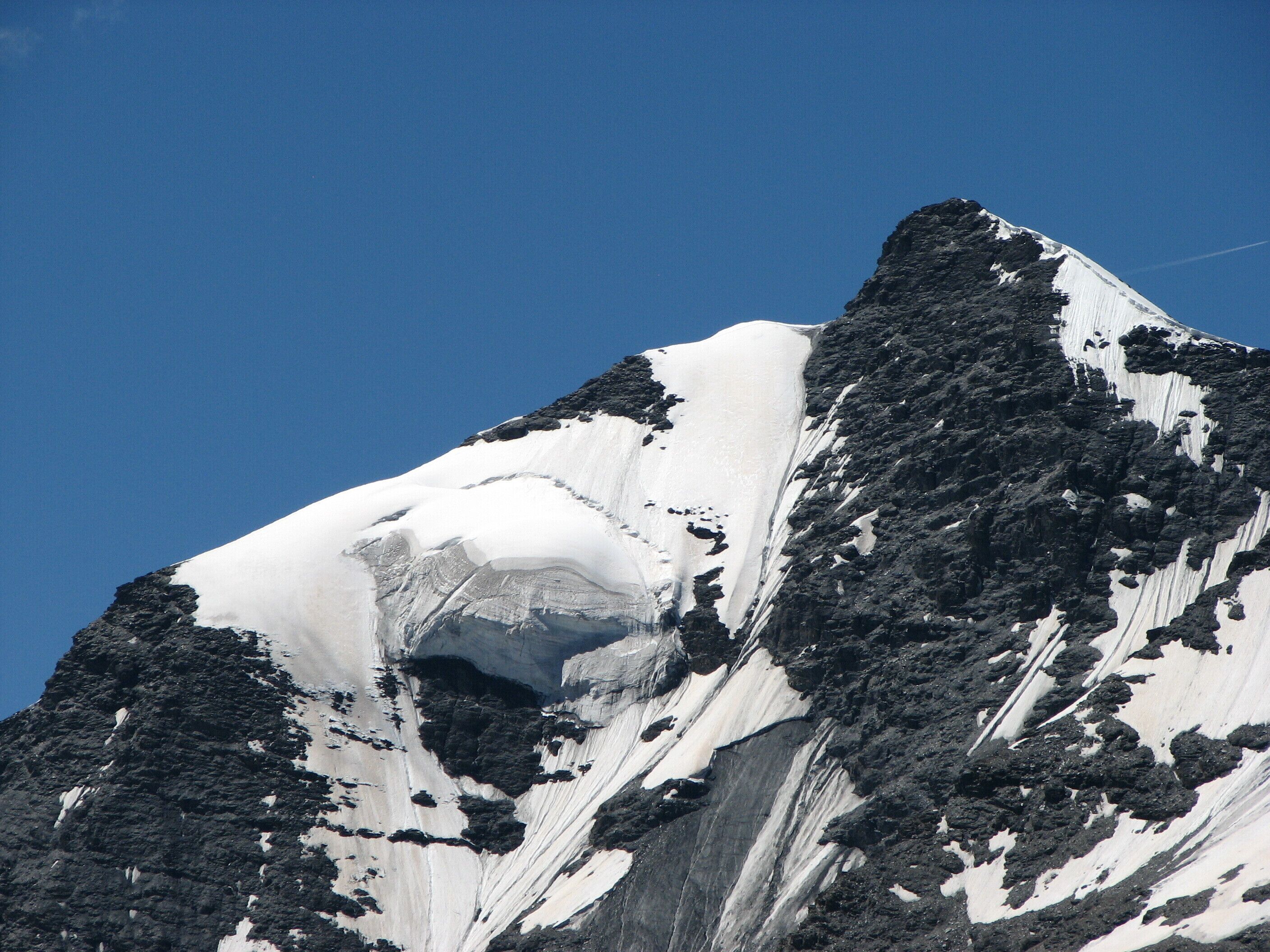 A snow-covered mountain peak with a visible crevasse.