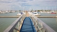 A marina with numerous sailboats docked at the pier.