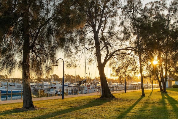 Callemondah showing a garden, a sunset and a bay or harbor