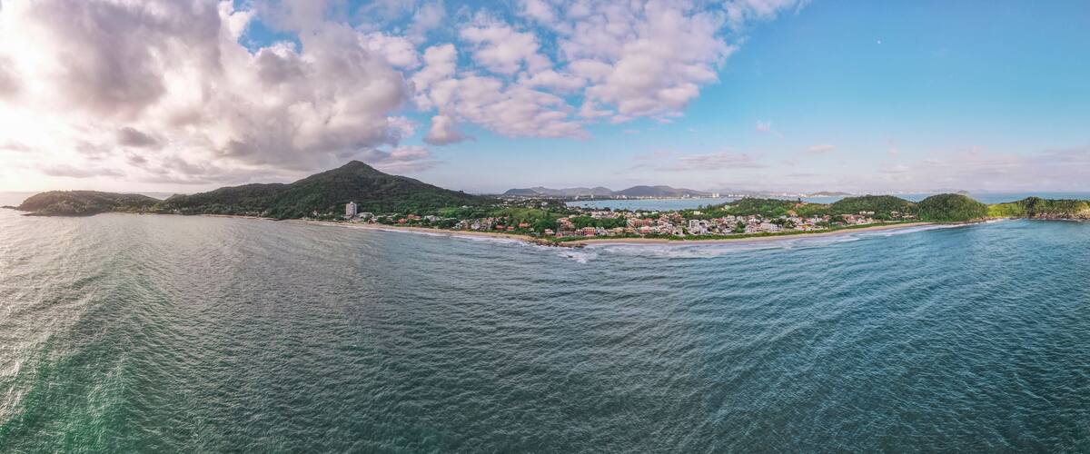 A coastal town with a mountain in the background and a clear sky.