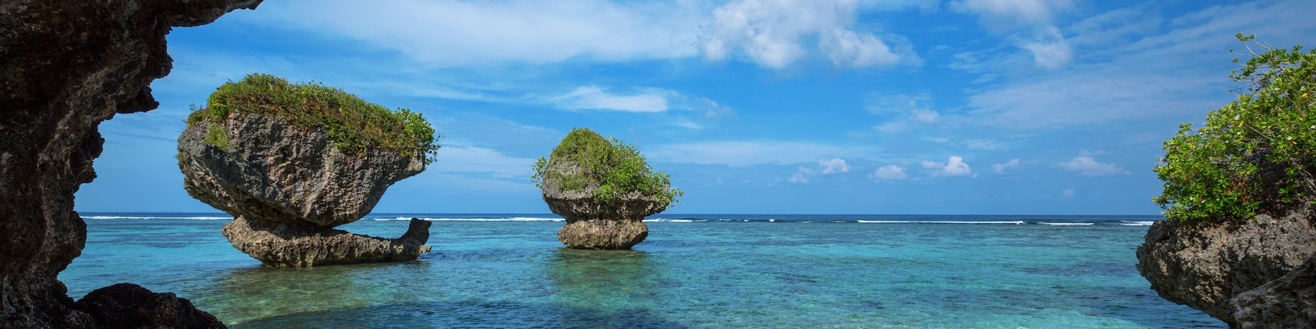 Beautiful rock formations along the sandy beach of Tanguisson Beach on the tropical island of Guam during the morning calm of the ocean on a clear, sunny day, Shutterstock ID 692727187, Purchase Order
