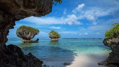 Beautiful rock formations along the sandy beach of Tanguisson Beach on the tropical island of Guam during the morning calm of the ocean on a clear, sunny day, Shutterstock ID 692727187, Purchase Order