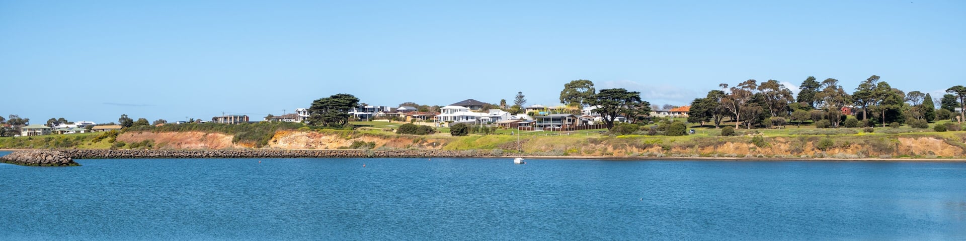 Beautiful panoramic coastal sea scenery in Portarlington, Victoria, Australia. Panorama background texture of a tranquil bay with calm, ocean water , and some residential houses along the waterfront