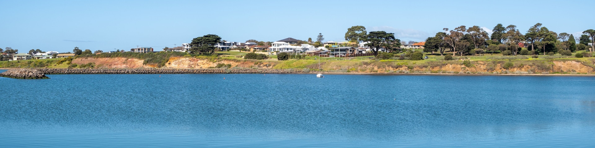 Beautiful panoramic coastal sea scenery in Portarlington, Victoria, Australia. Panorama background texture of a tranquil bay with calm, ocean water , and some residential houses along the waterfront