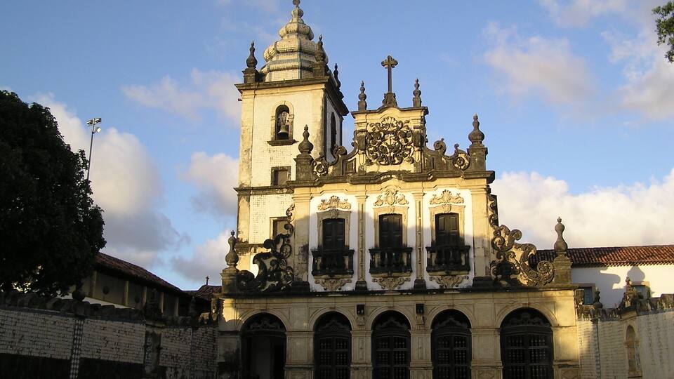 A historic church with a bell tower, ornate facade, and arched windows.