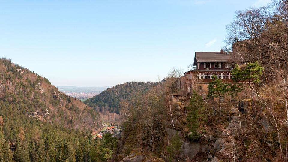 A house on a hillside overlooking a valley.