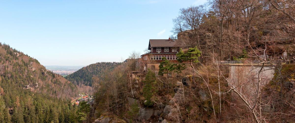 A house on a hillside overlooking a valley.