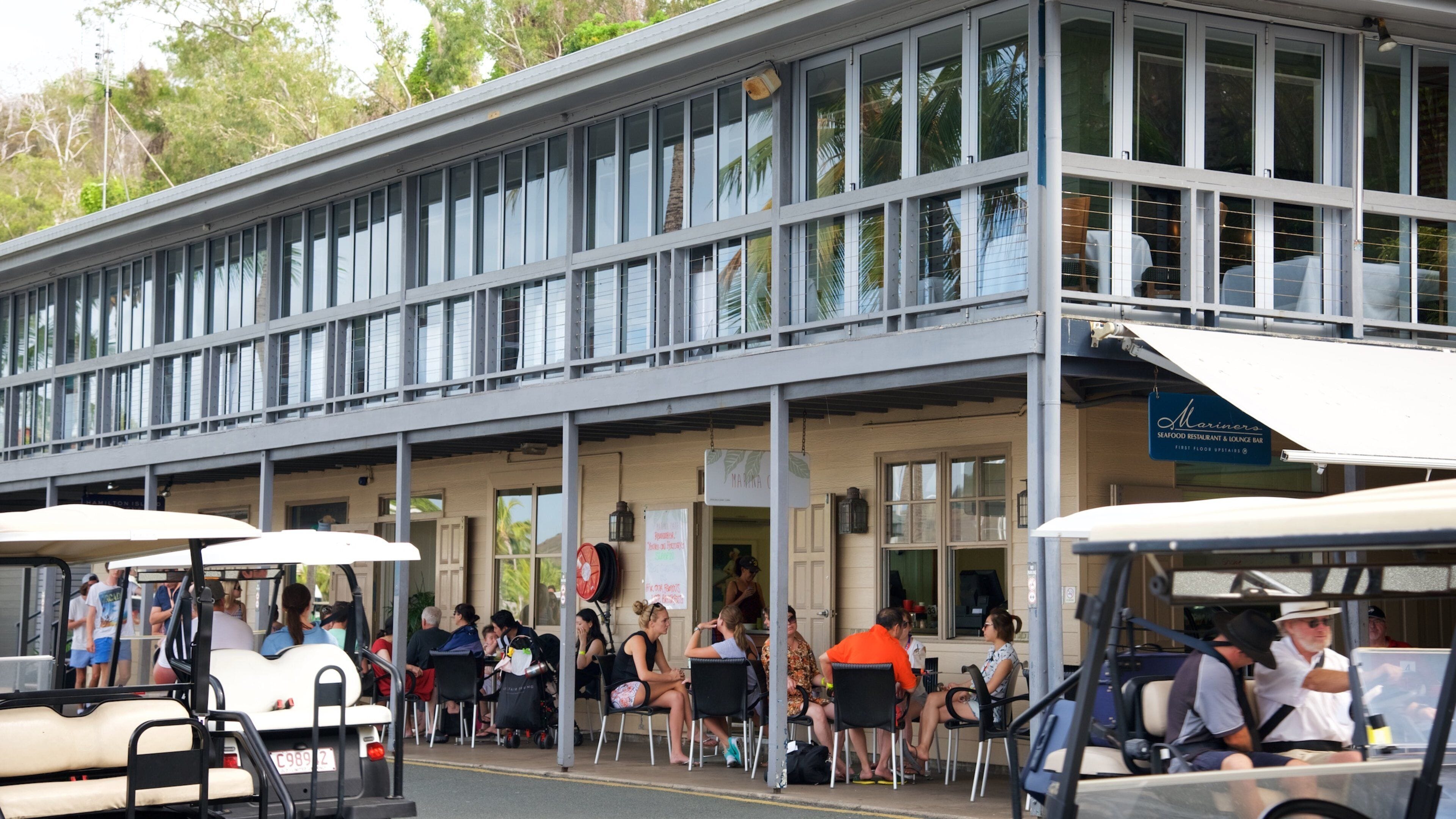 Hamilton Island Marina showing dining out and street scenes as well as a small group of people