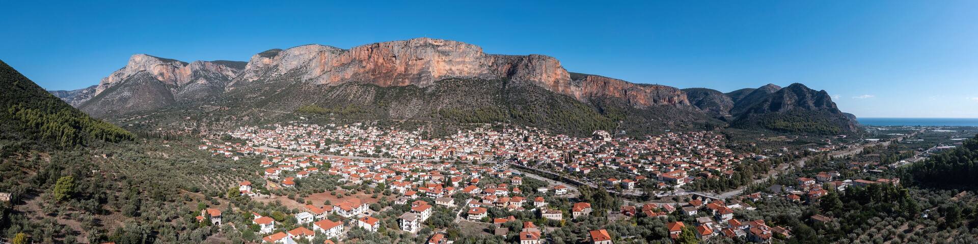 Greece, Leonidio, Arcadia, Peloponnese. Aerial drone panoramic view of town, mountain, cliff. Banner