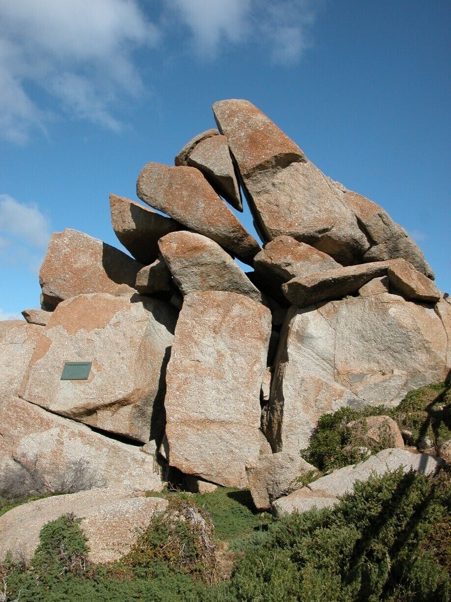 A large rock formation with a plaque.