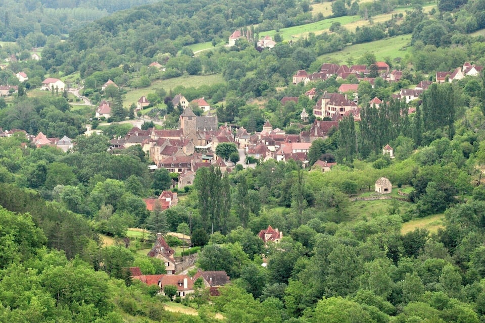 Un pueblo enclavado en un valle exuberante, rodeado de bosques densos.