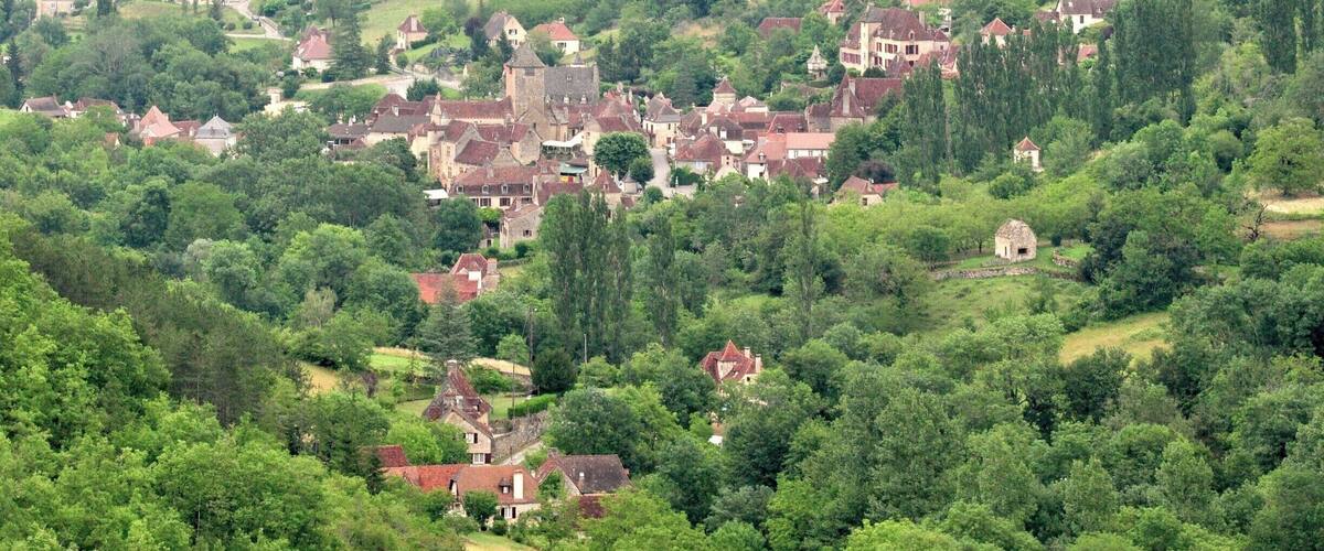 A village nestled in a lush valley surrounded by dense forests.