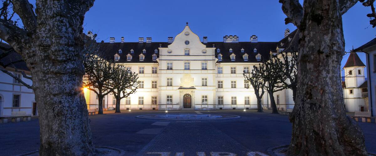A historic building with a symmetrical facade, large windows, and a central entrance.