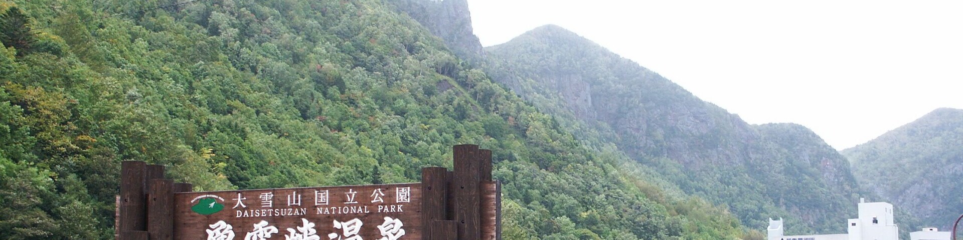 A sign for Daishizusan National Park with a mountainous backdrop.