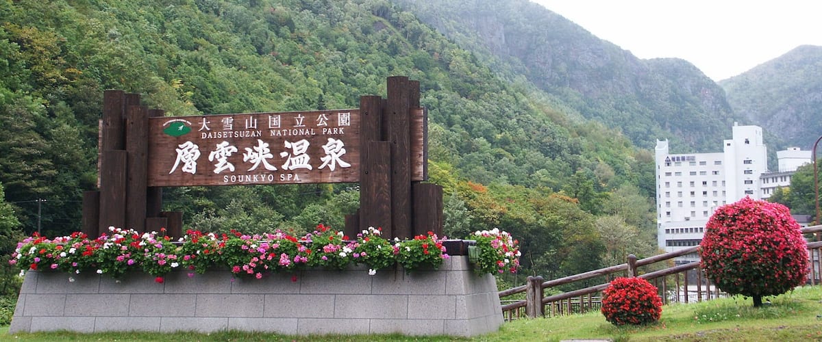A sign for Daishizusan National Park with a mountainous backdrop.