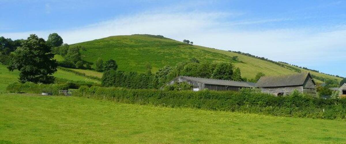 View towards Caer Caradoc The farm buildings are at the east end of the hamlet of Chapel Lawn in the Redlake valley. A high and more visited hill named Caer Caradoc is to the east of All Stretton, giving two hillforts in Shropshire accredited to the early British leader known by the Romans as Caractacus.