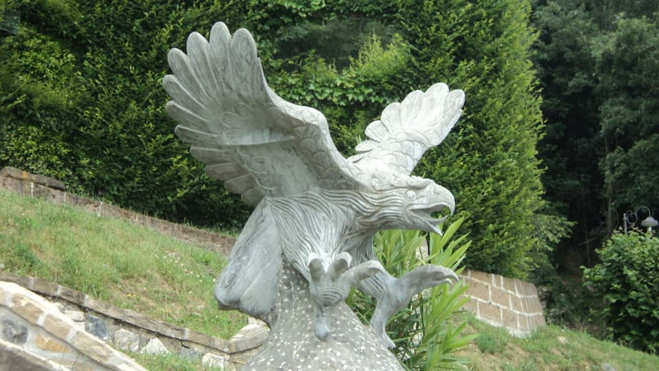 A stone eagle sculpture with outstretched wings.