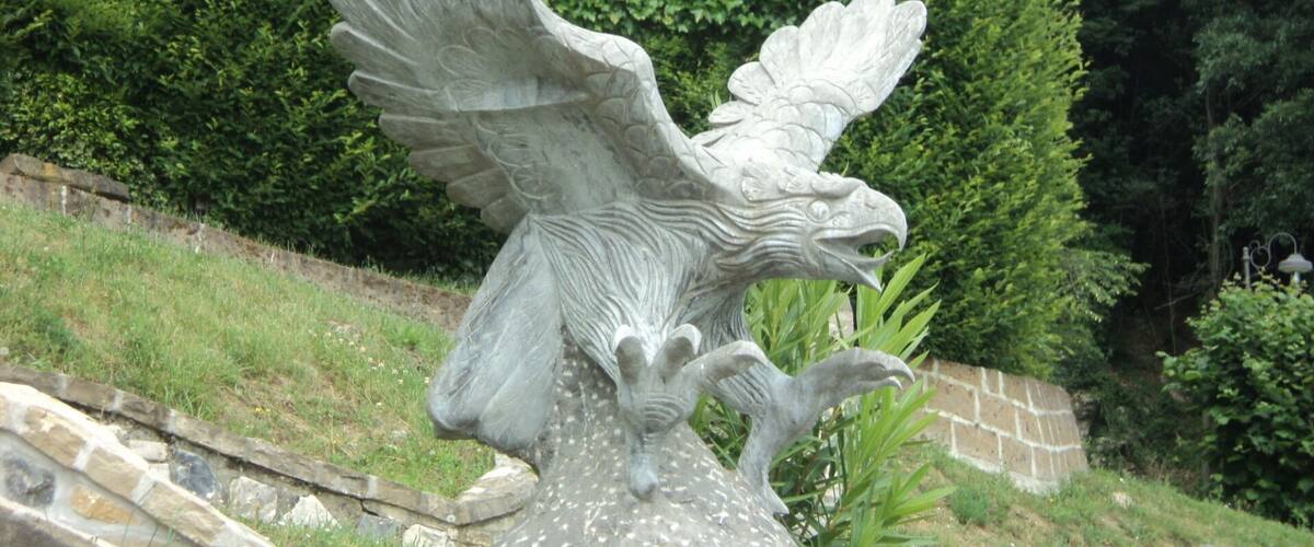 A stone eagle sculpture with outstretched wings.