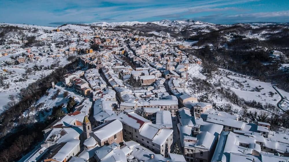 A snow-covered town with historic buildings and a church.