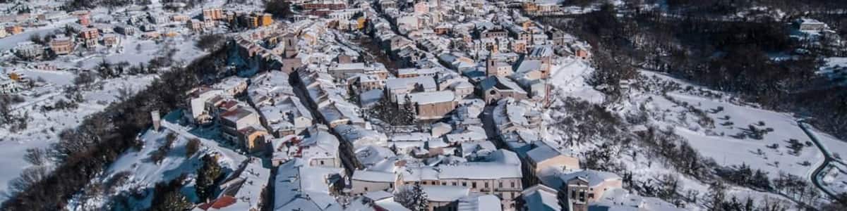 Une ville enneigée, avec des bâtiments historiques et une église.