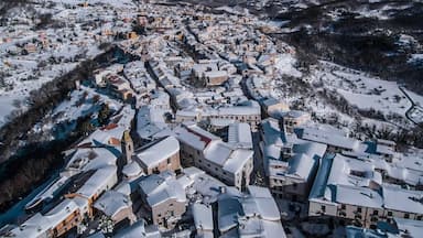 Uma cidade coberta de neve com edifícios históricos e uma igreja.