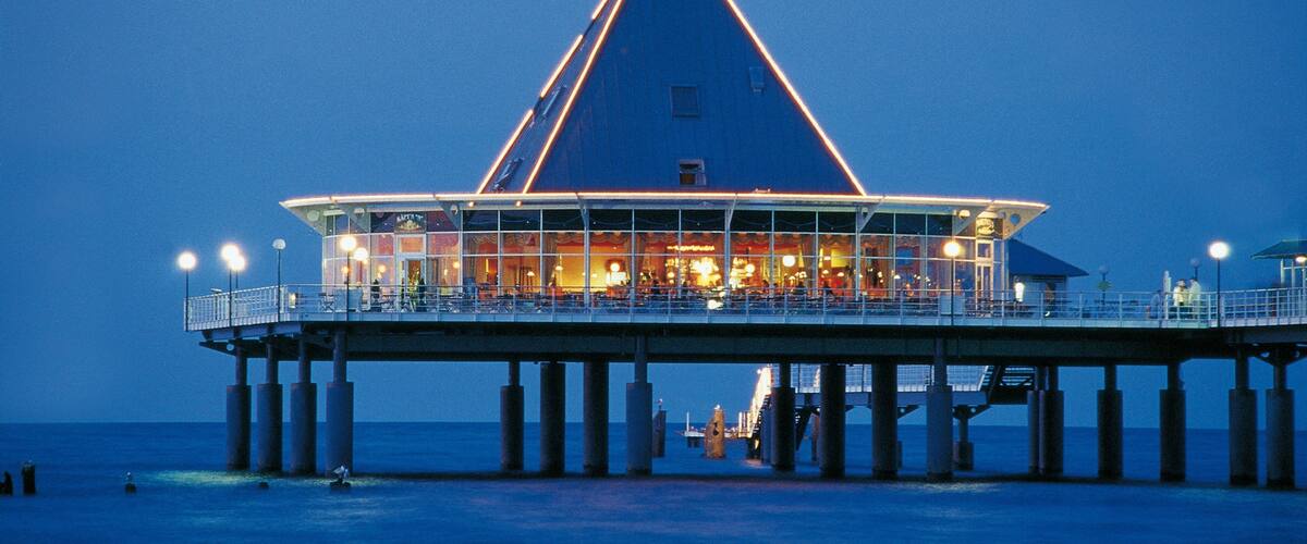 A pier with a triangular structure and a restaurant at the end.