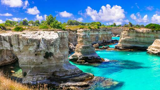 Ultra-wide panorama of Torre Sant'Andrea rock formations and turquoise Adriatic sea, Salento, Puglia, Italy. Iconic limestone sea stacks near Otranto at summer.