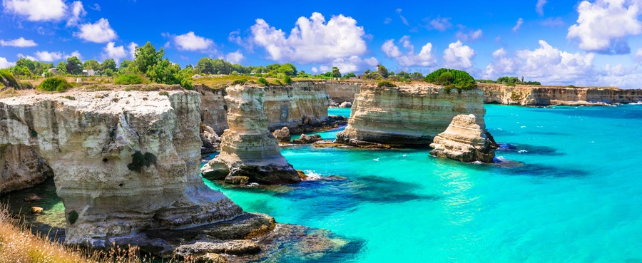 Ultra-wide panorama of Torre Sant'Andrea rock formations and turquoise Adriatic sea, Salento, Puglia, Italy. Iconic limestone sea stacks near Otranto at summer.