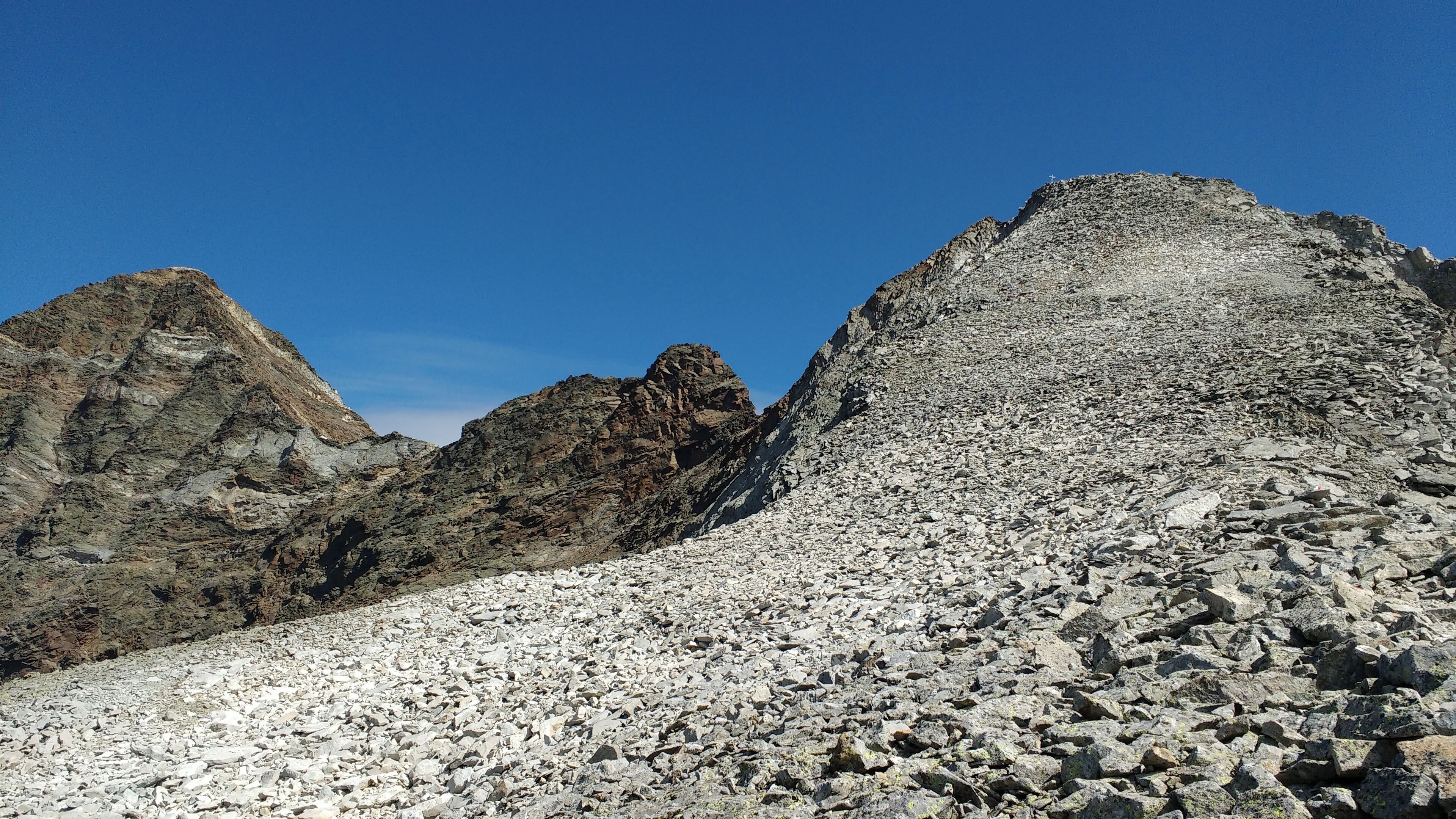 A rocky mountain landscape with rugged peaks and a clear blue sky.