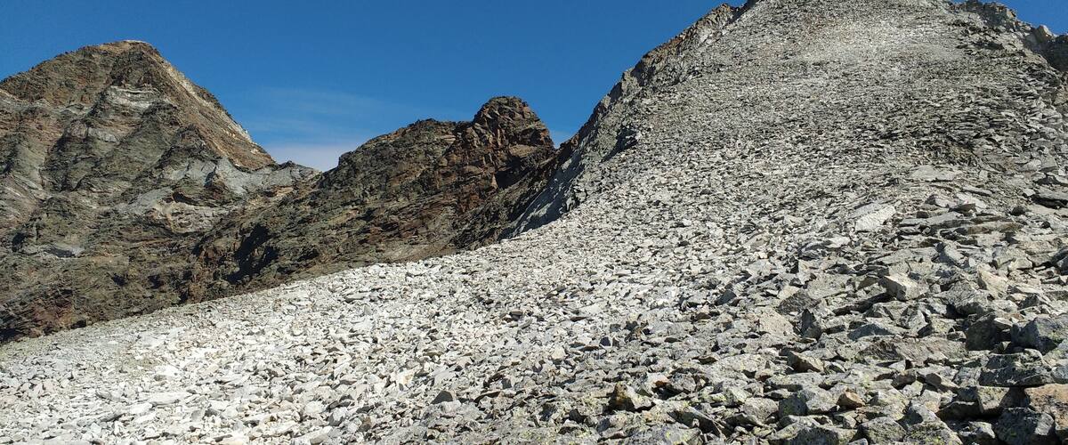A rocky mountain landscape with rugged peaks and a clear blue sky.