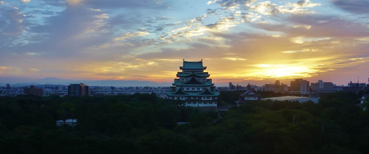 A traditional Japanese pagoda with a sunset in the background.