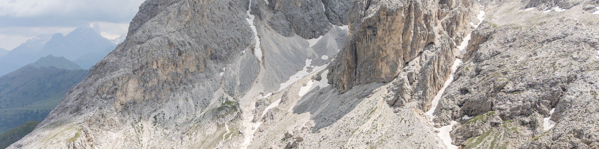 Un paisaje montañoso con un camino sinuoso y picos rocosos.