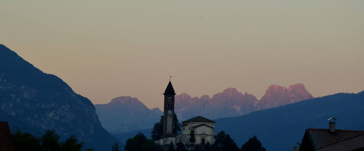 A church with a bell tower surrounded by mountains.