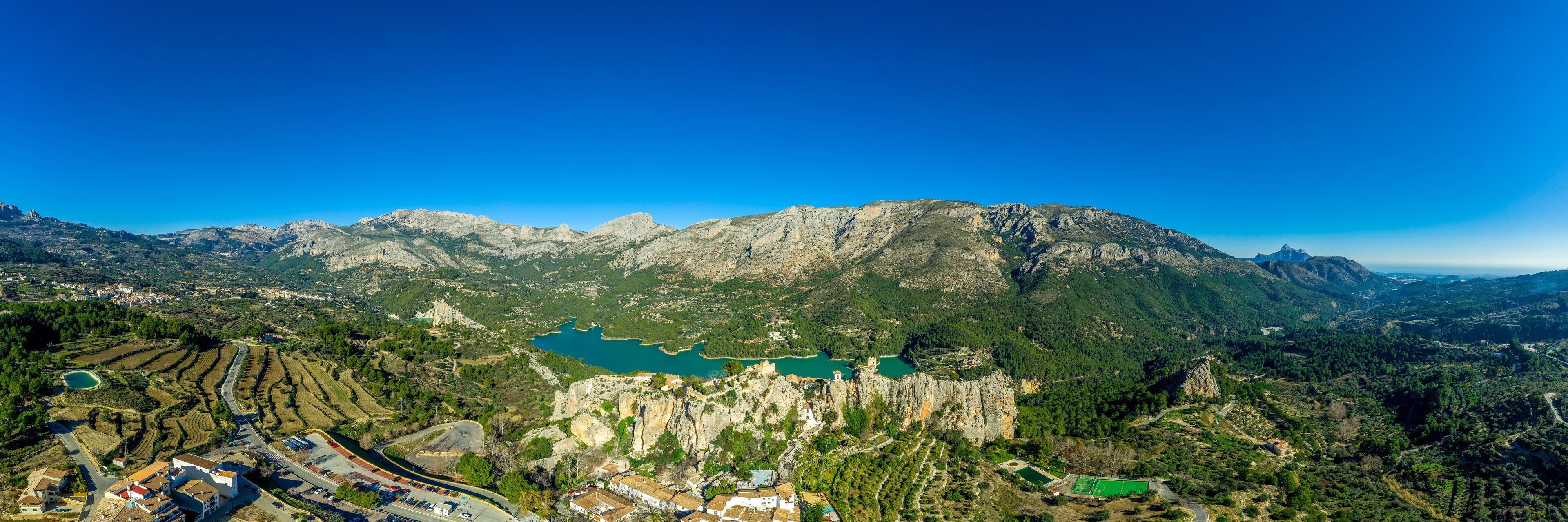 Panoramic view of popular Spanish vacation destination El Castell de Guadalest above a beautiful water reservoir with 2 castles and fortified enclave