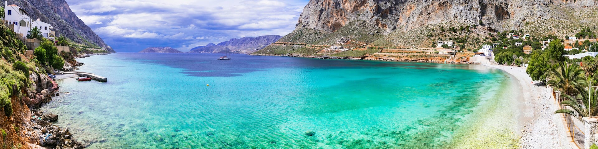 A coastal town with clear turquoise waters, white sandy beaches, and rocky cliffs.