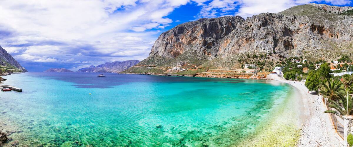 A coastal town with clear turquoise waters, white sandy beaches, and rocky cliffs.