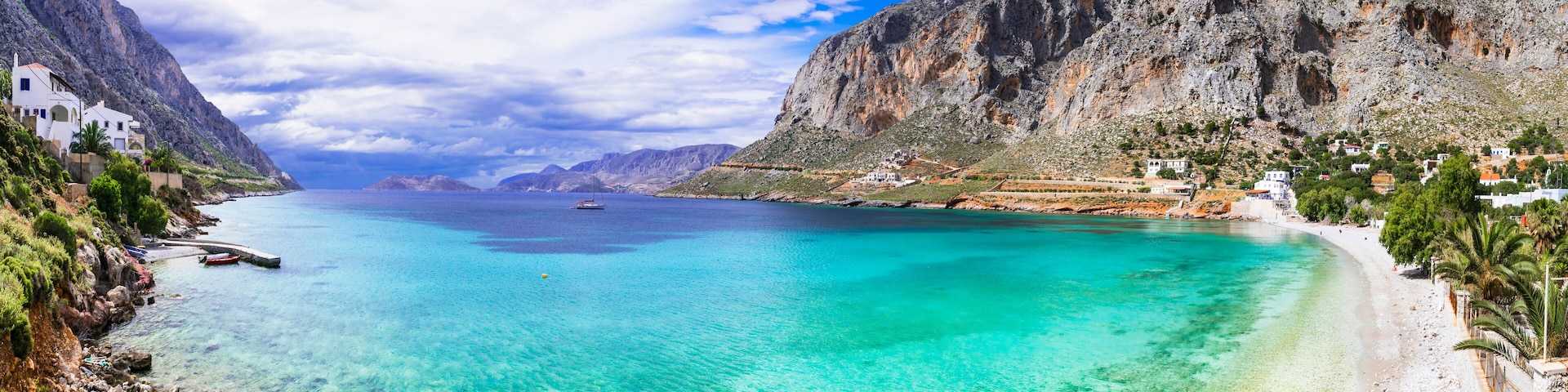 A coastal town with clear turquoise waters, white sandy beaches, and rocky cliffs.