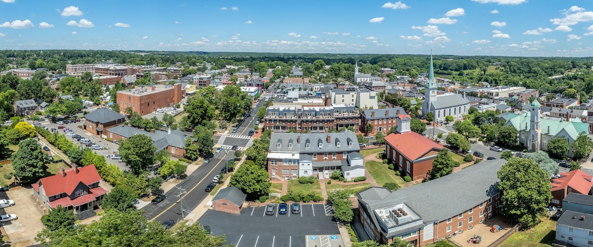 A town with a prominent church, a large parking lot, and a mix of residential and commercial buildings.