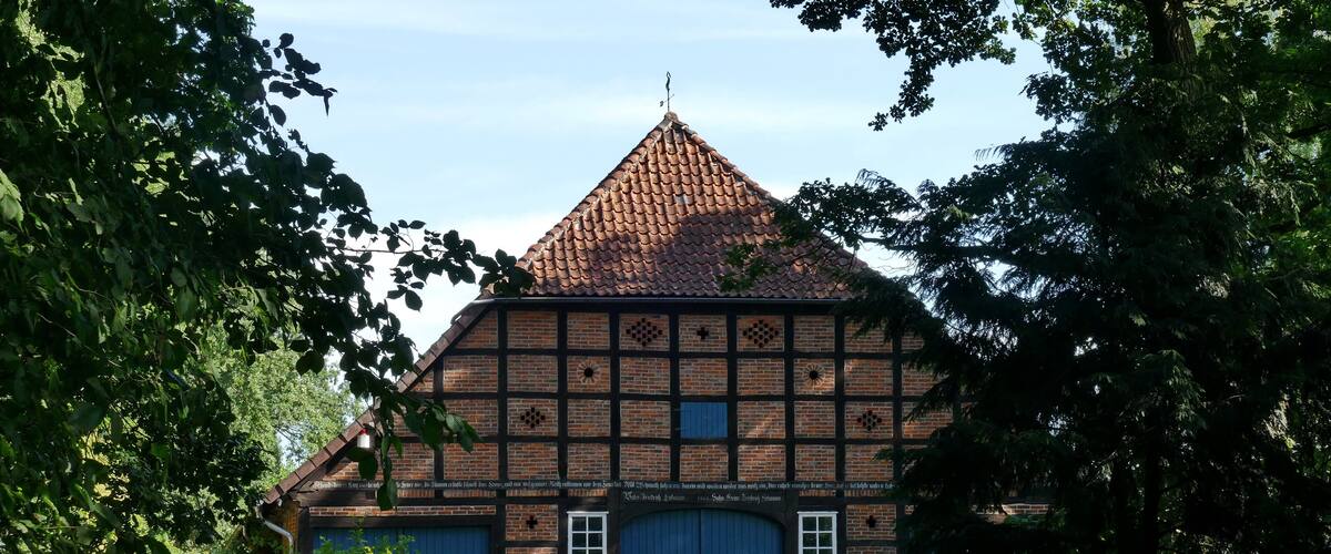 A traditional half-timbered house with a steeply pitched roof and a blue door.