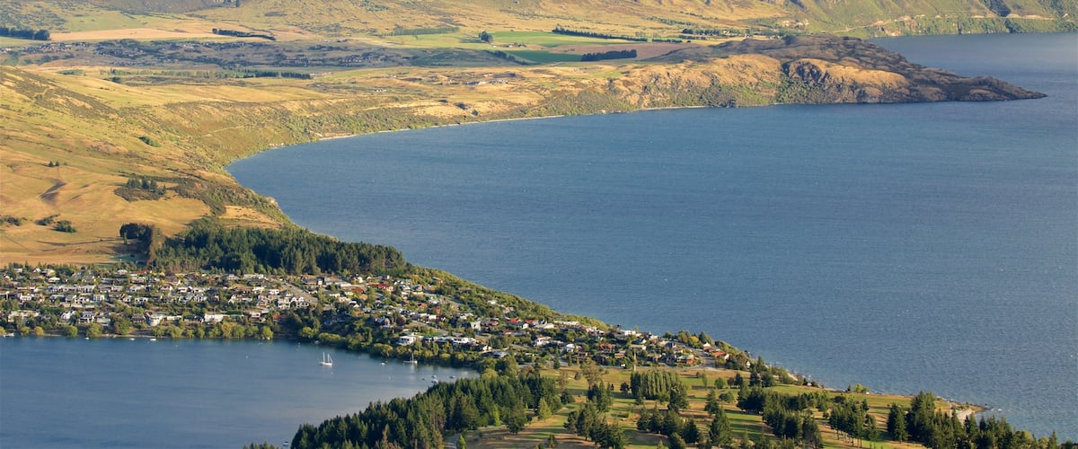 A coastal town with a bay, surrounded by mountains.