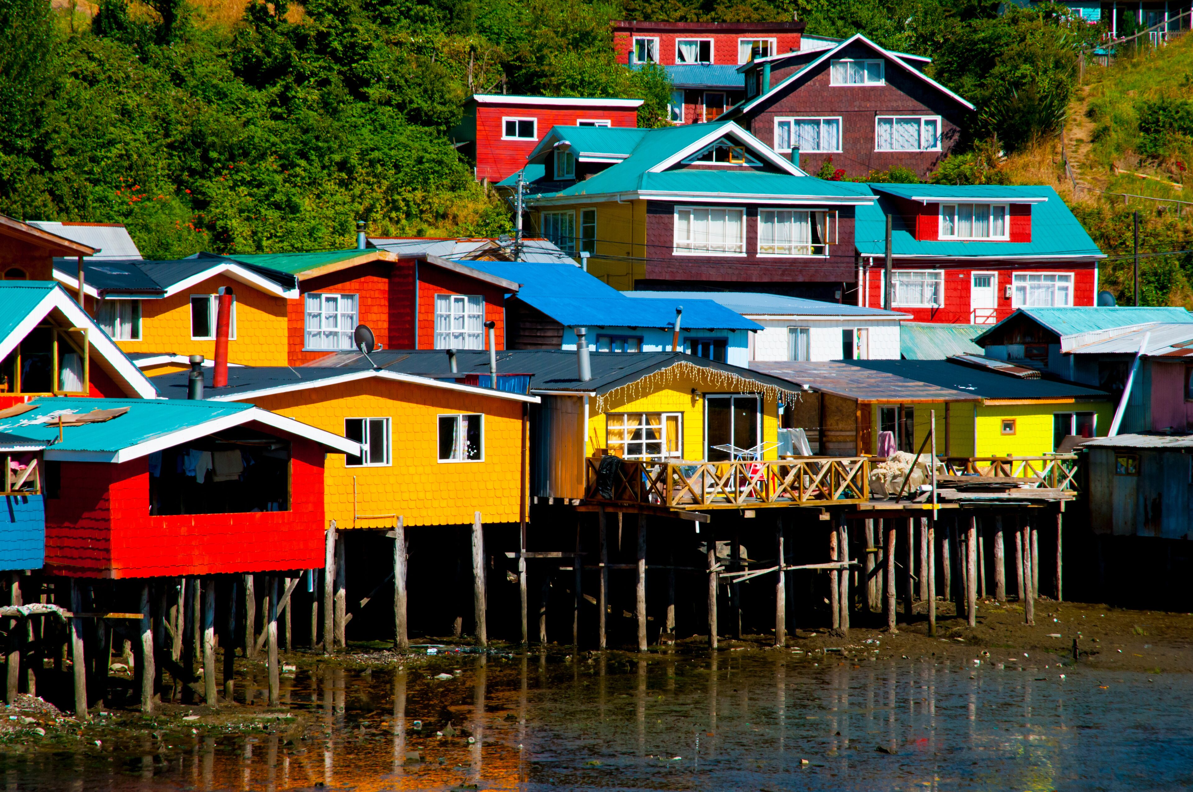 Colorful houses on stilts by a body of water.