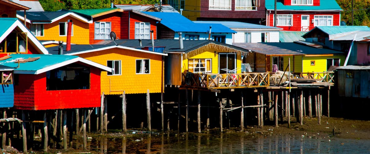 Colorful houses on stilts by a body of water.