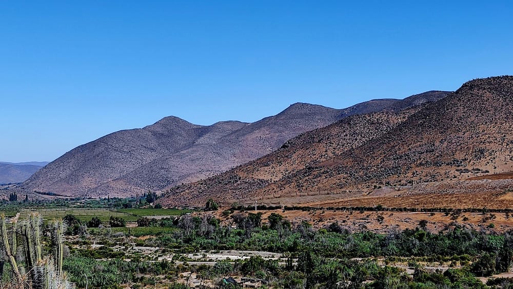 A mountainous landscape with a valley in the foreground.
