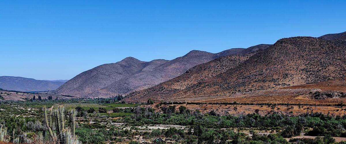 A mountainous landscape with a valley in the foreground.