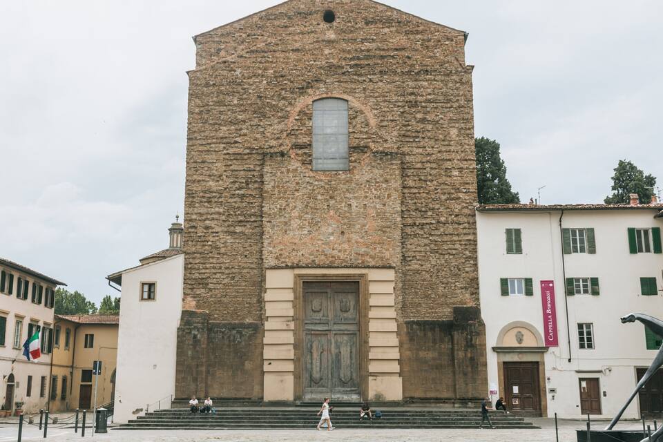 Igreja de pedra histórica com uma grande porta de madeira e degraus que a levam.