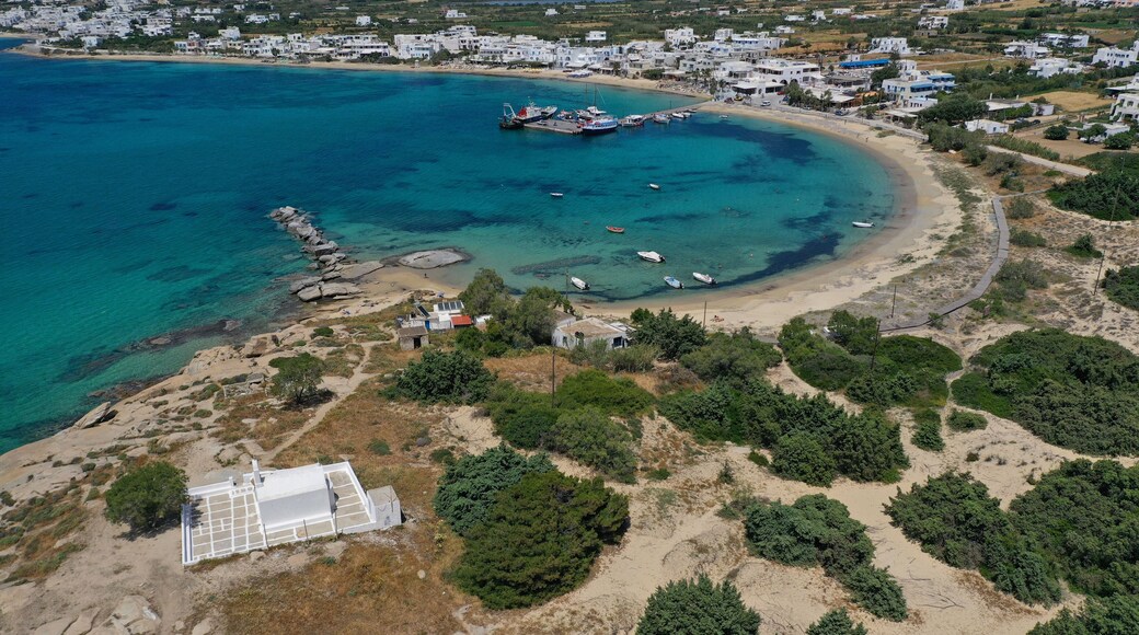 Aerial drone photo of breathtaking turquoise round sandy beach and small village and small seaside picturesque chapel of Agia Anna, Naxos island, Cyclades, Greece